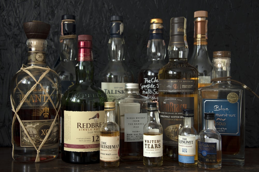 clear glass bottles on brown wooden shelf