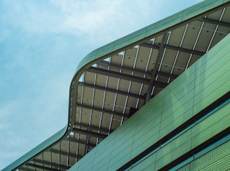 green and black glass walled building under blue sky during daytime