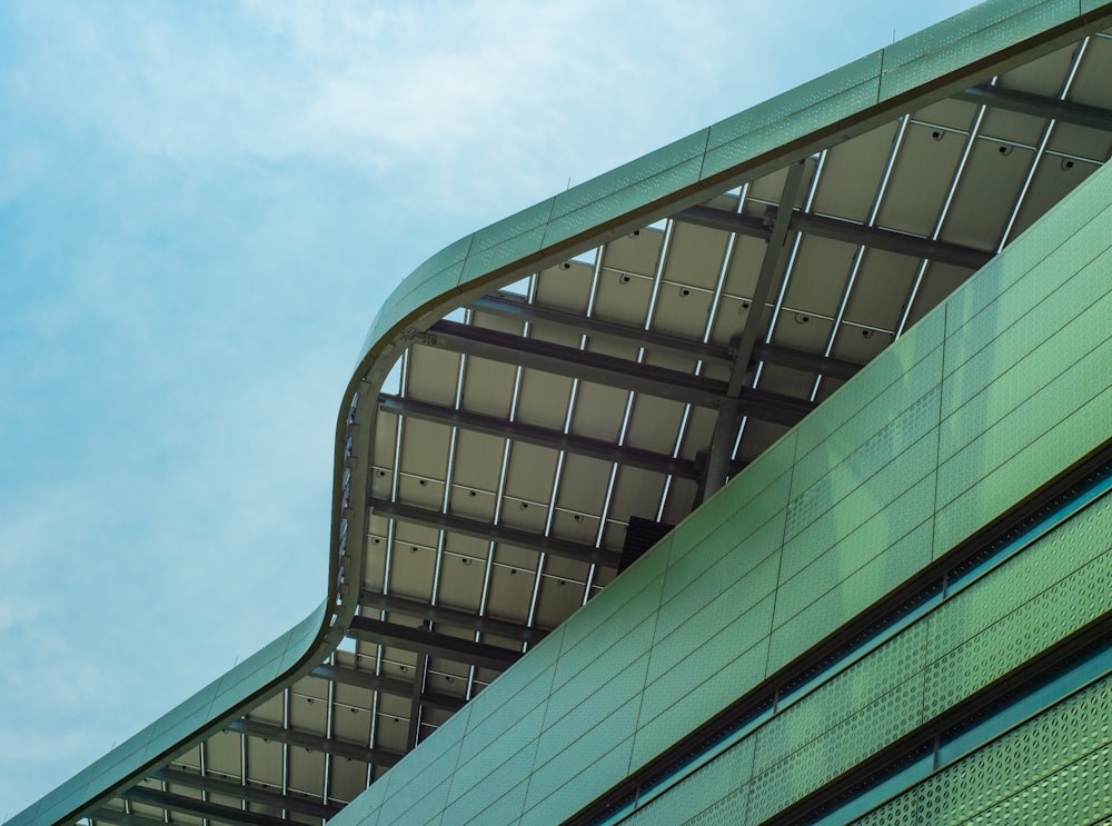 green and black glass walled building under blue sky during daytime