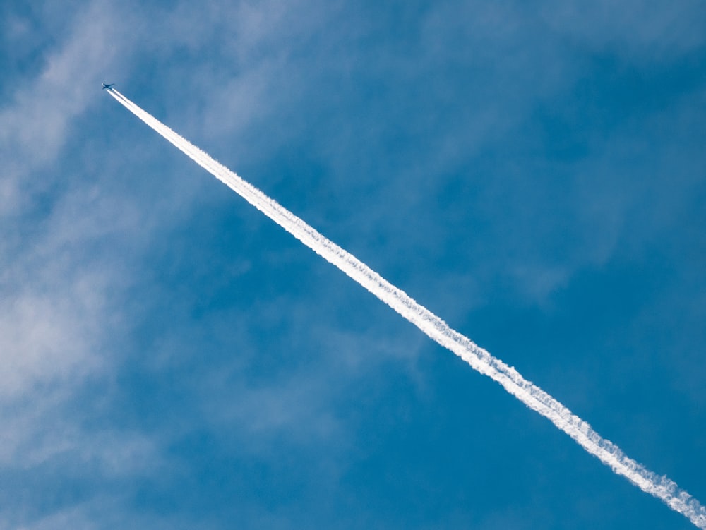 Weißes Düsenflugzeug am blauen Himmel