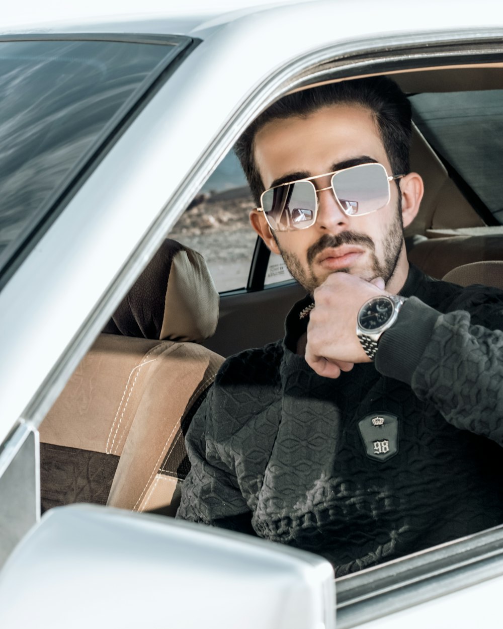 man in black jacket and black sunglasses sitting on car seat