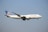 A large passenger airplane with 'United' written on the side is flying against a clear blue sky. The aircraft has a distinctive blue and gold globe logo on its tail.