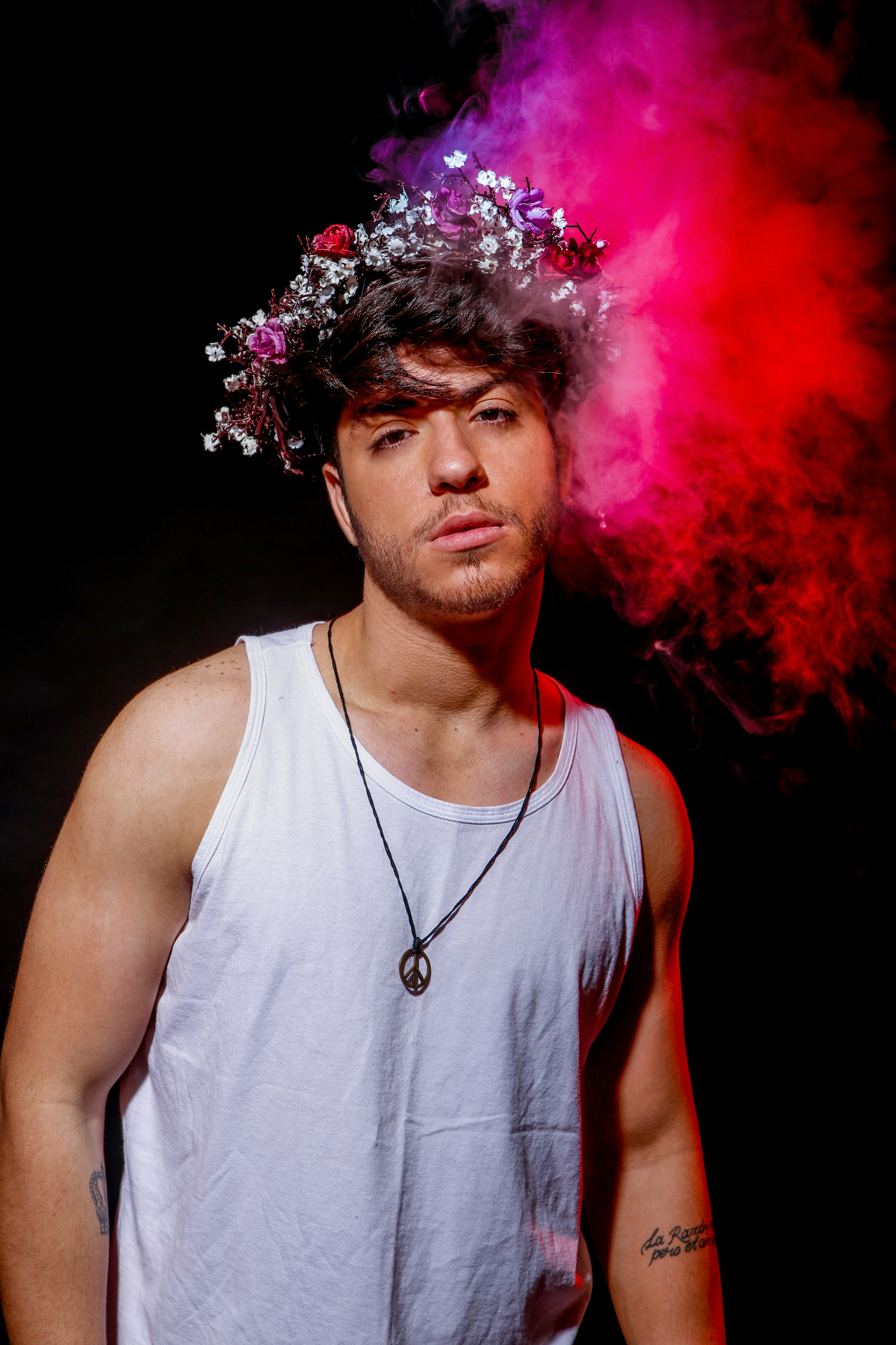 hombre con camiseta blanca sin mangas con polvo púrpura en la cabeza