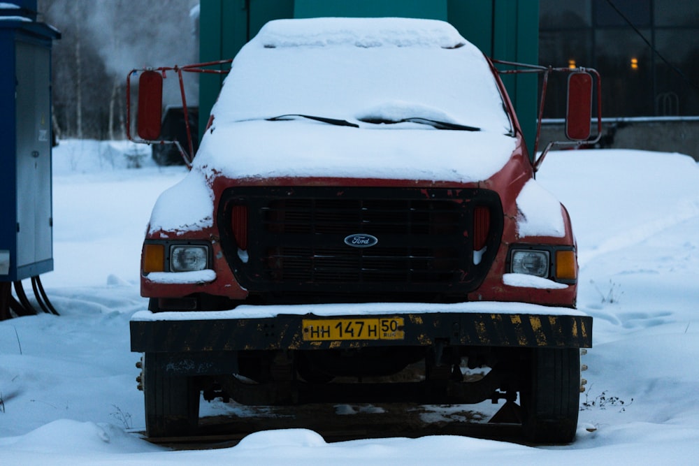 red ford car on snow covered road during daytime