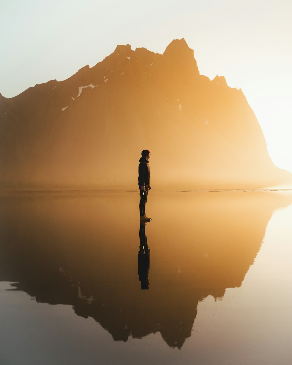 silhouette of woman standing on water during daytime