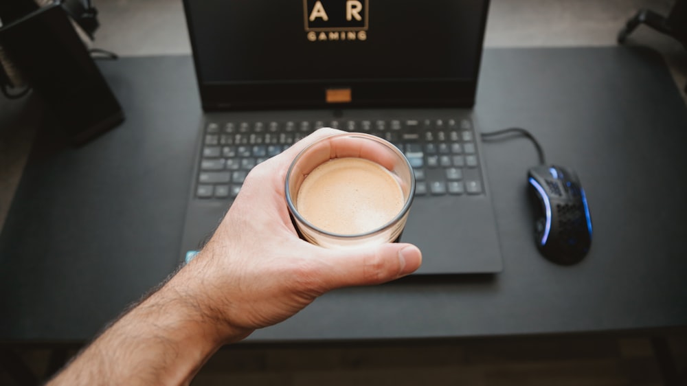 person holding white ceramic mug