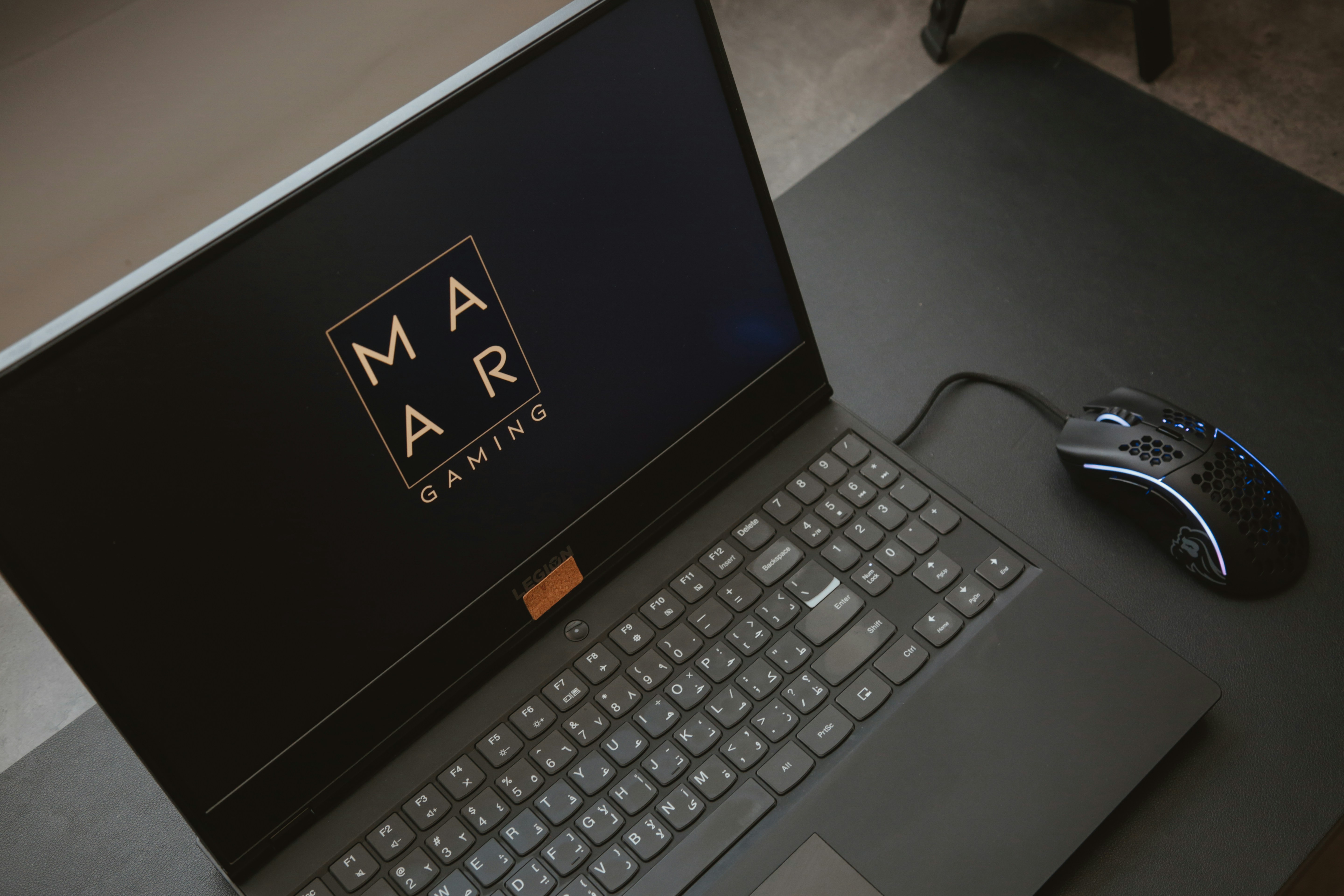 computadora portátil negra encendida en una mesa blanca