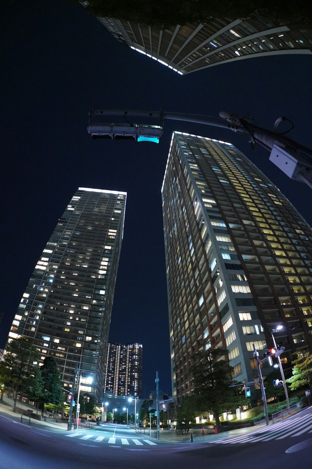 cars on road in between high rise buildings during night time