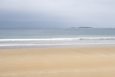 brown sand near body of water during daytime