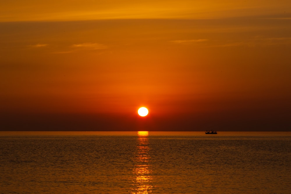 Silueta de persona en la playa durante la puesta del sol