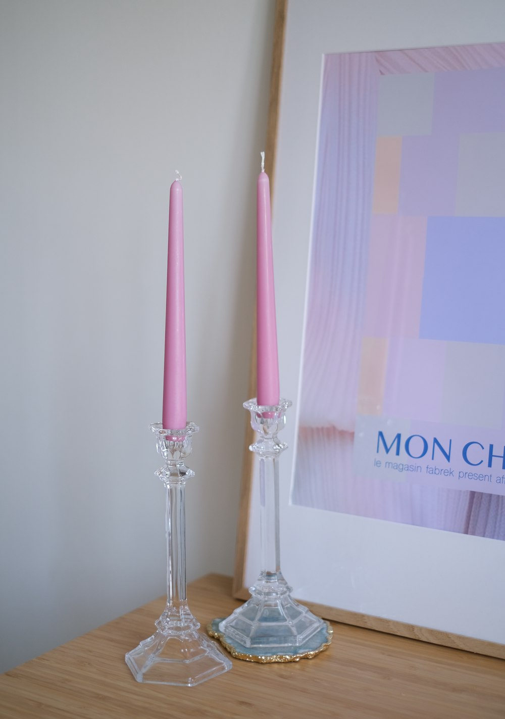2 white and pink candles on clear glass candle holder