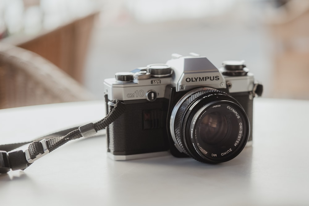 black and silver canon dslr camera on white table