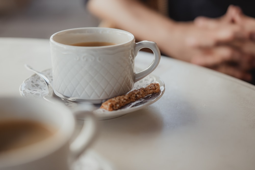 white ceramic mug on white ceramic saucer