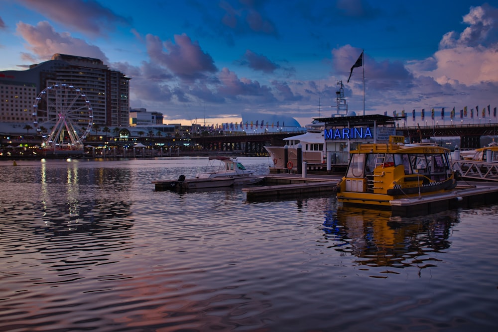 white and yellow boat on water near city buildings during daytime