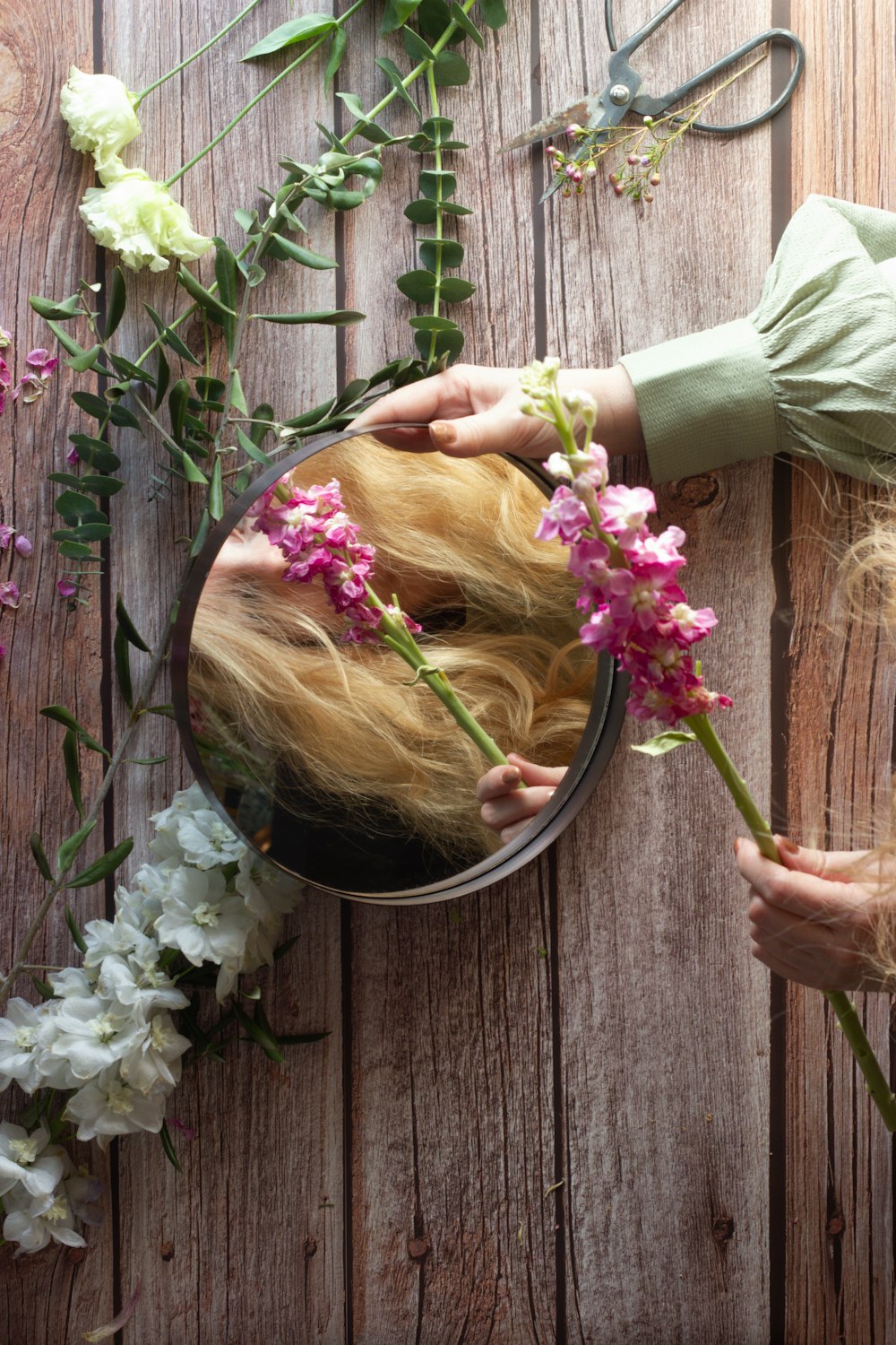 ピンクと白の花を持つピンクのシャツを着た女性