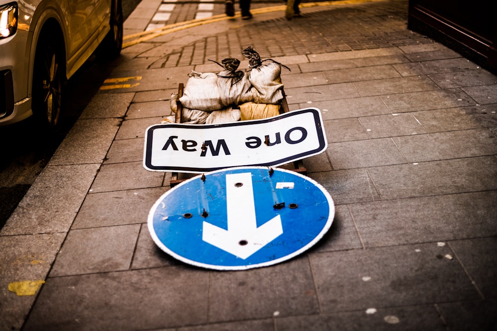 uma placa de rua azul e branca sentada ao lado de uma estrada