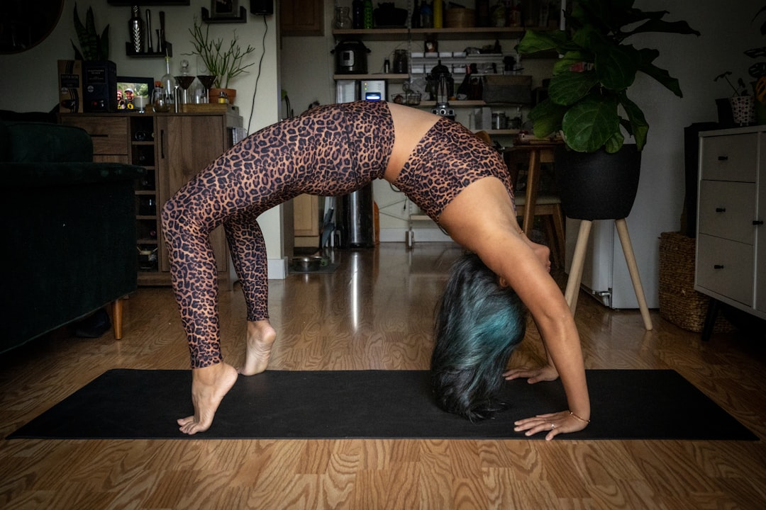 woman in black and white polka dots leggings bending her body on brown wooden table