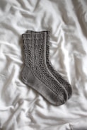gray sock on white textile