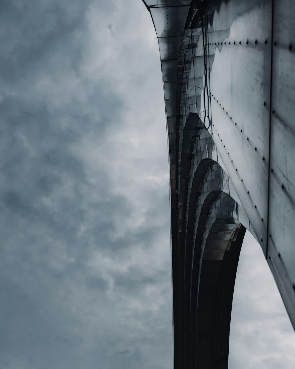 low angle photography of bridge under cloudy sky during daytime