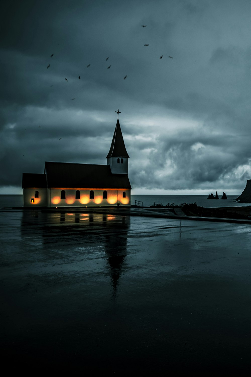 white and black concrete building near body of water under cloudy sky