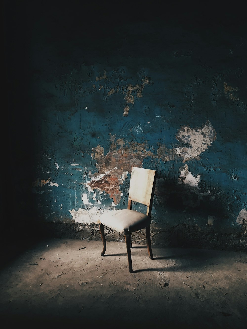 青いコンクリートの床に白と黒の椅子