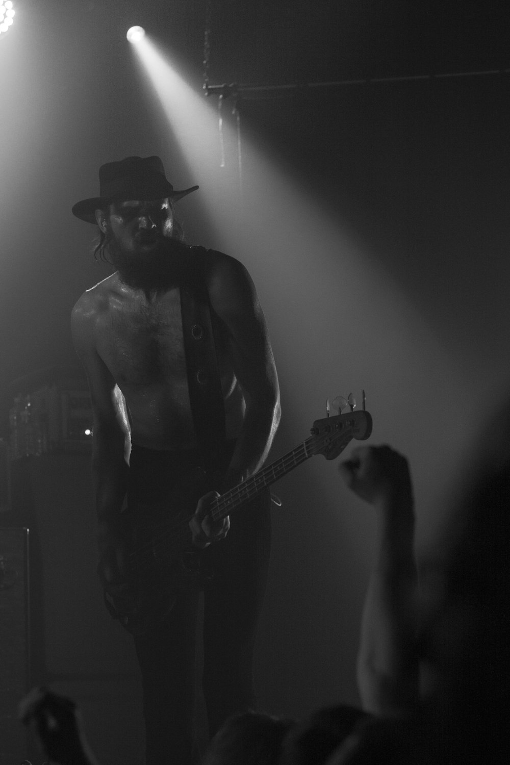 man in black tank top playing guitar