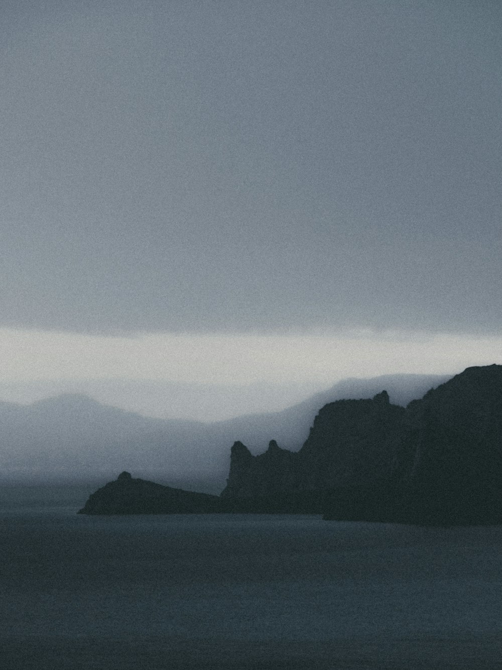 black mountains near body of water during daytime