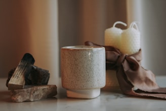 An assortment of personalized mugs and candles arranged on a rustic wooden table.
