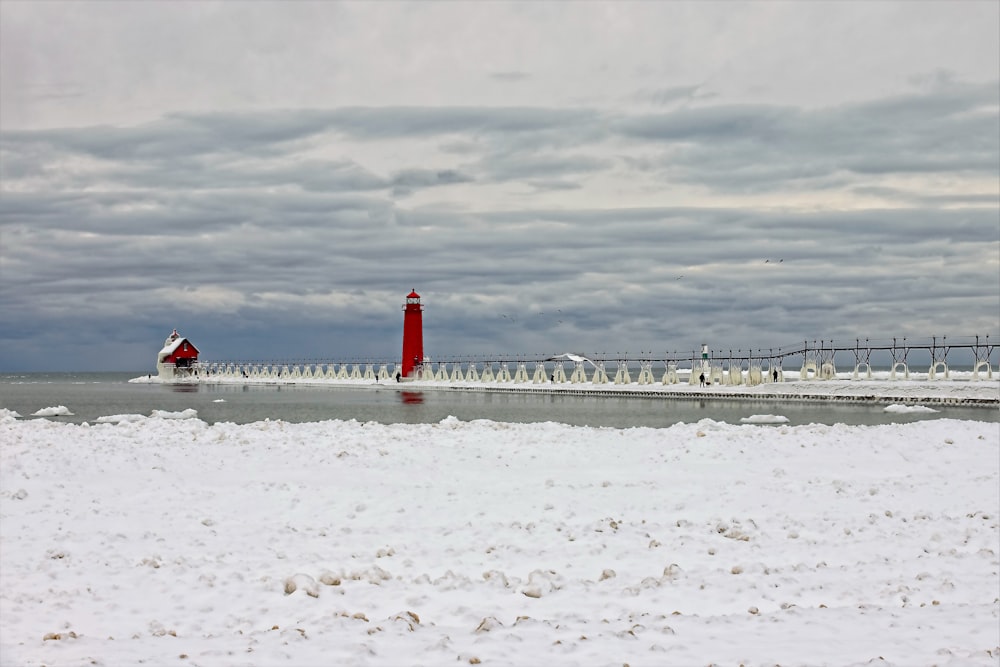 red and white lighthouse on white sand during daytime