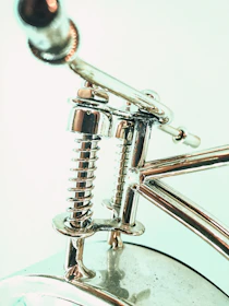 Close-up photo of a shiny torsion spring installed on a garage door.