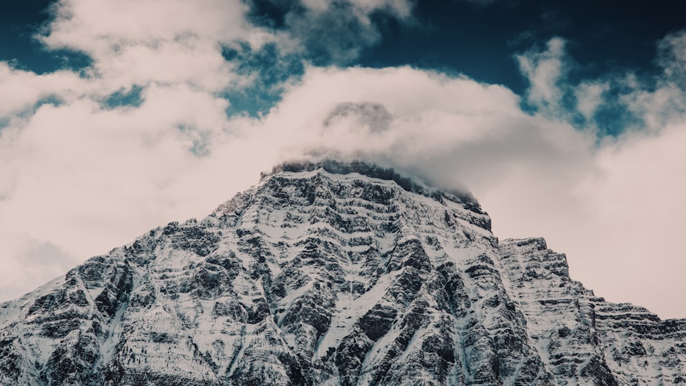 snow covered mountain under cloudy sky during daytime