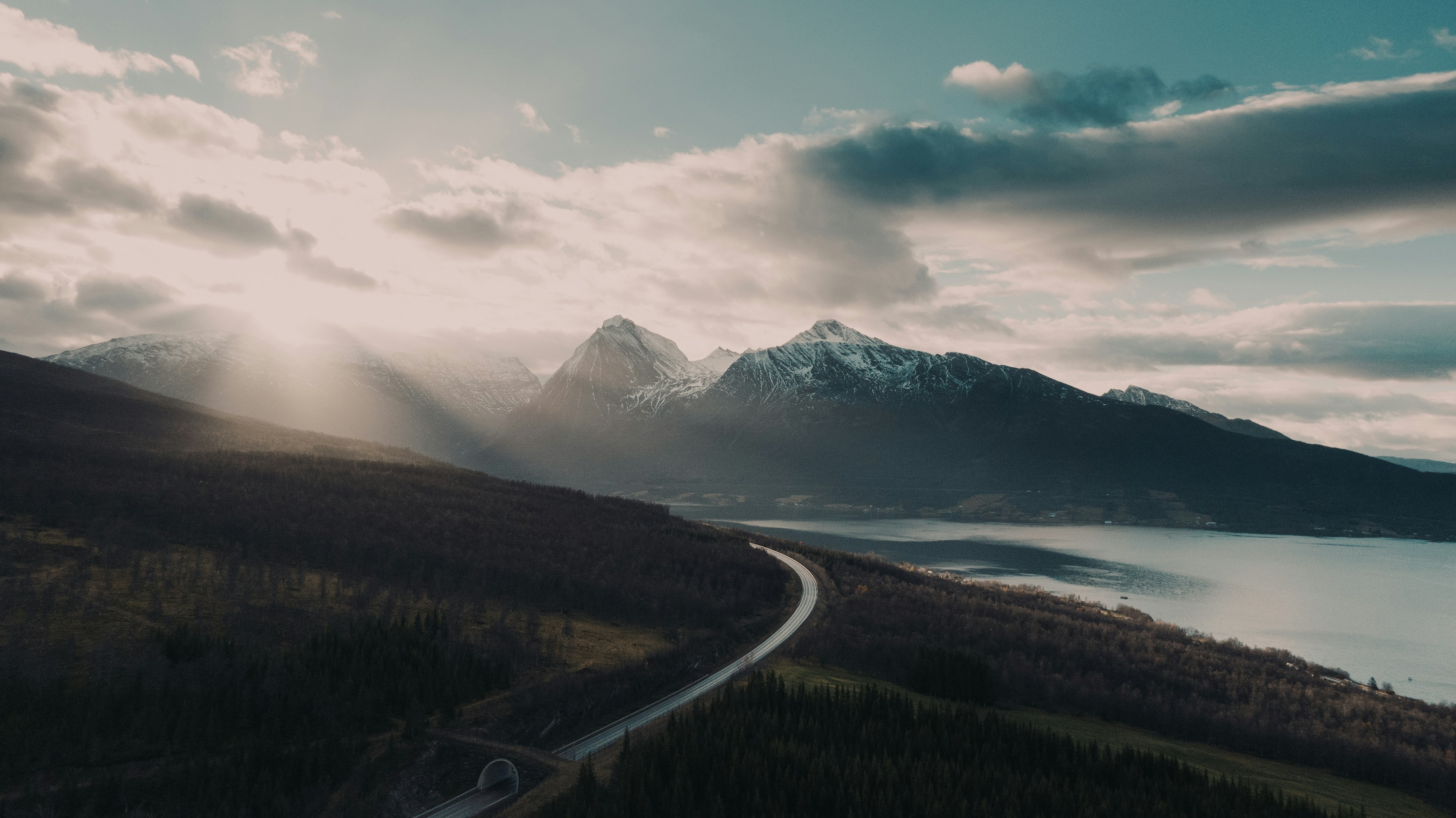 árboles verdes cerca de la montaña bajo el cielo nublado durante el día