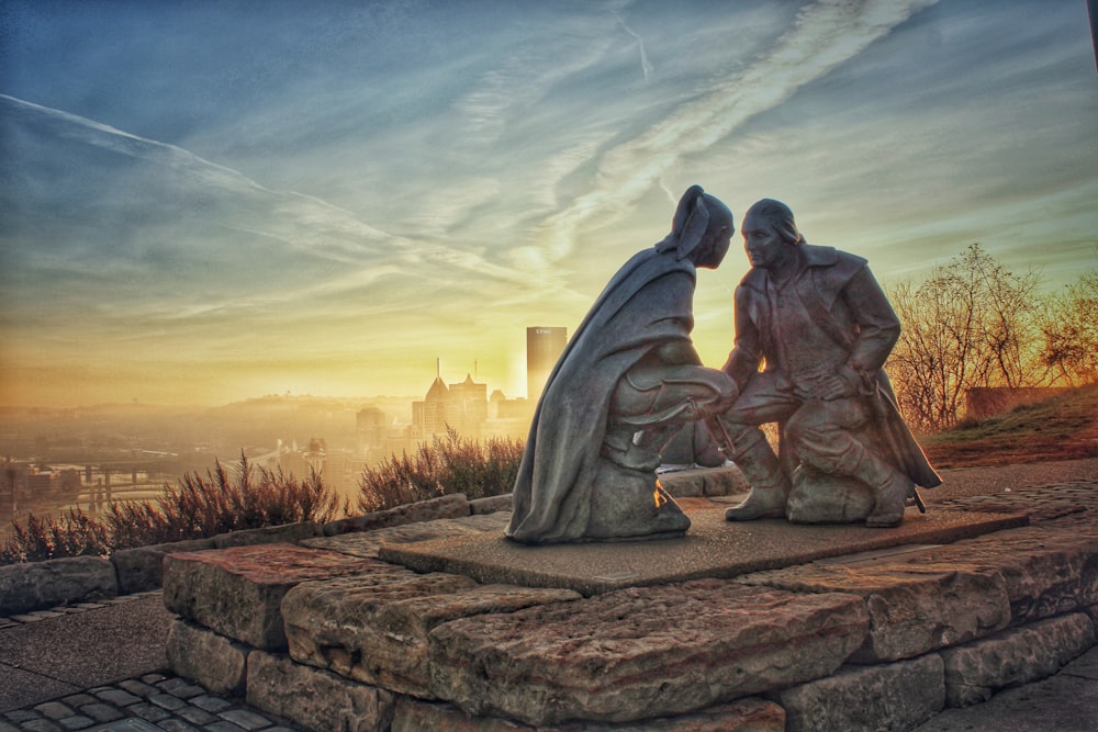 man sitting on rock formation during sunset