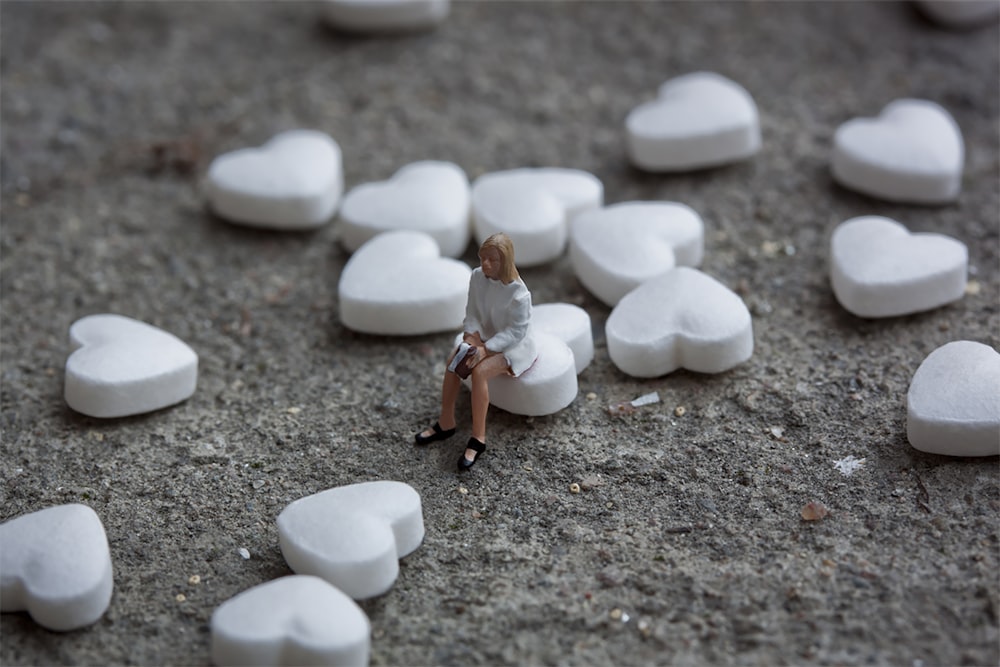 woman in white shirt and brown pants standing on white pebbles