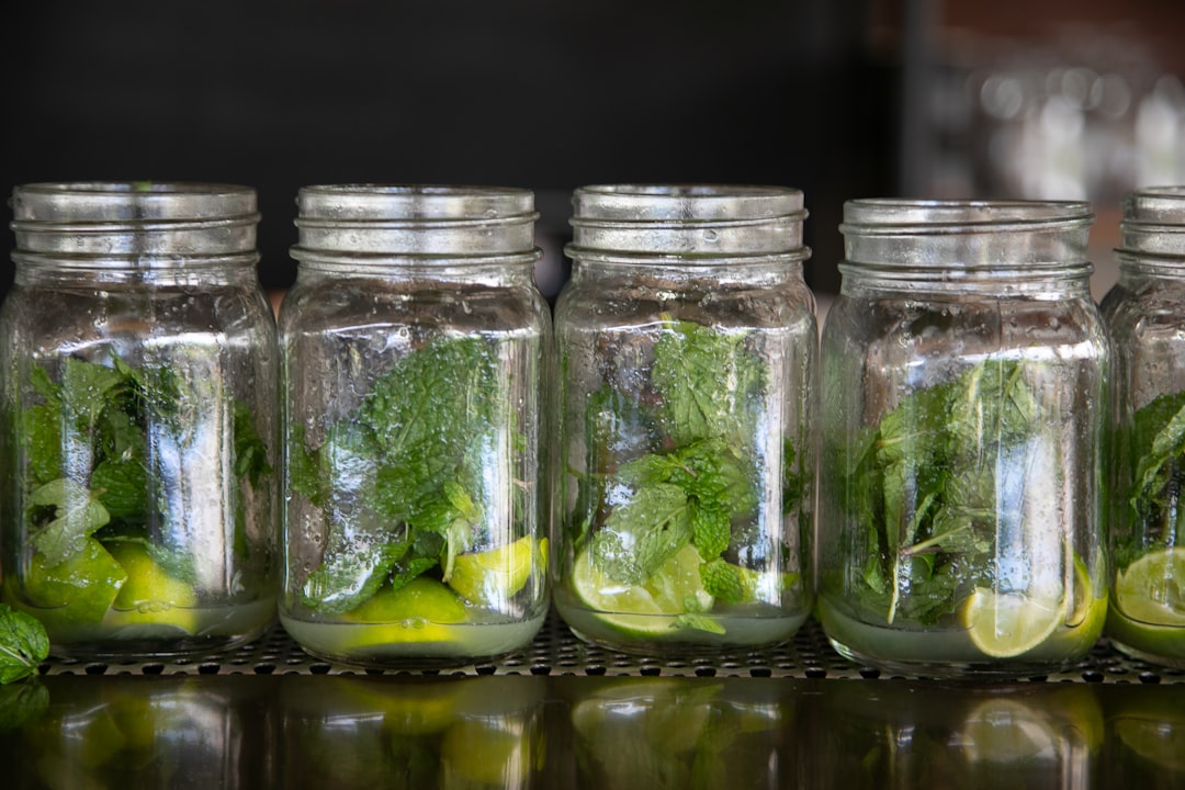 green and white leaves in clear glass jars