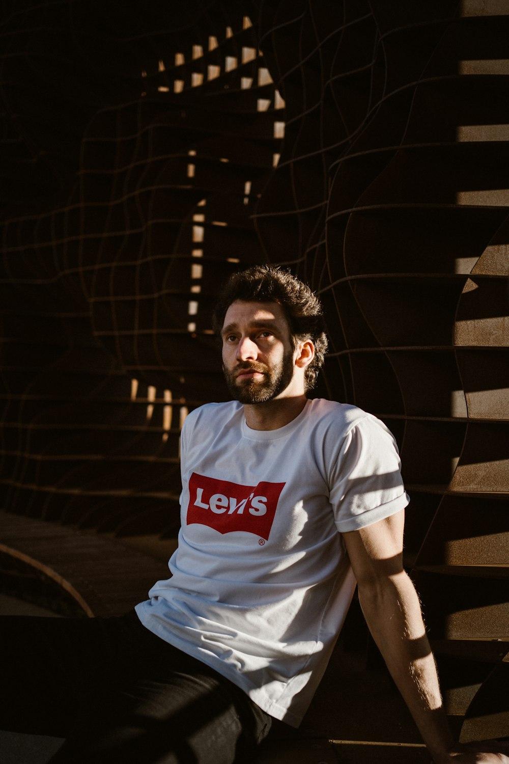 man in white crew neck t-shirt standing near stairs