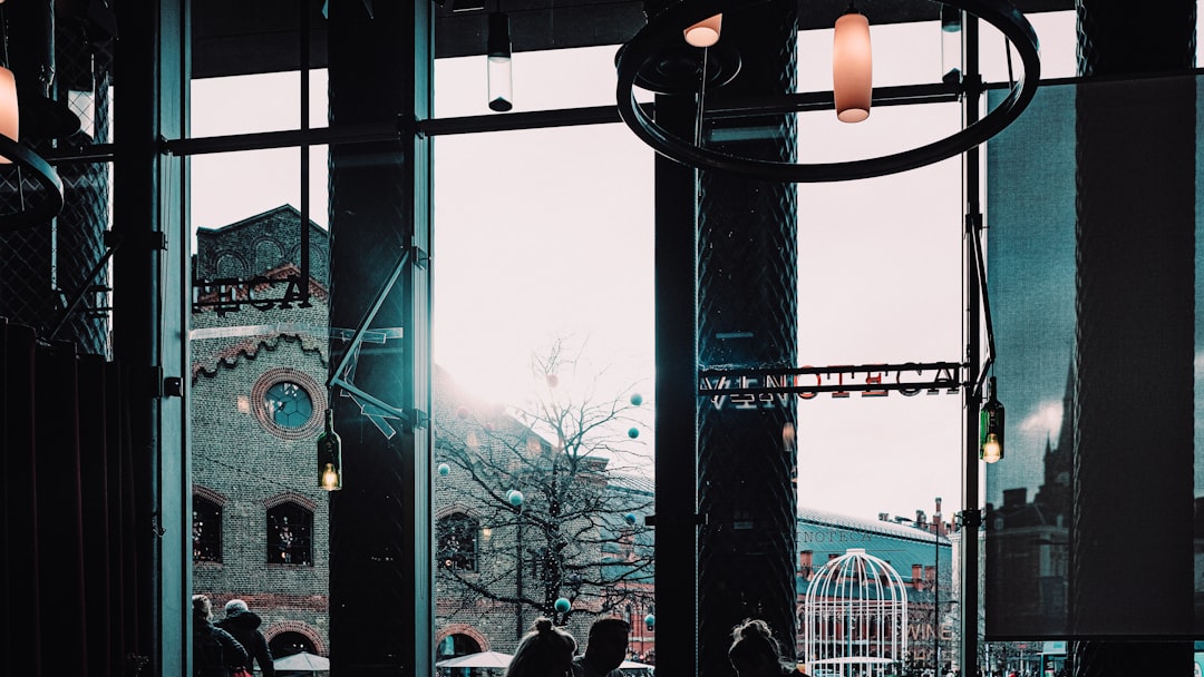 people walking on sidewalk near black metal gate during daytime