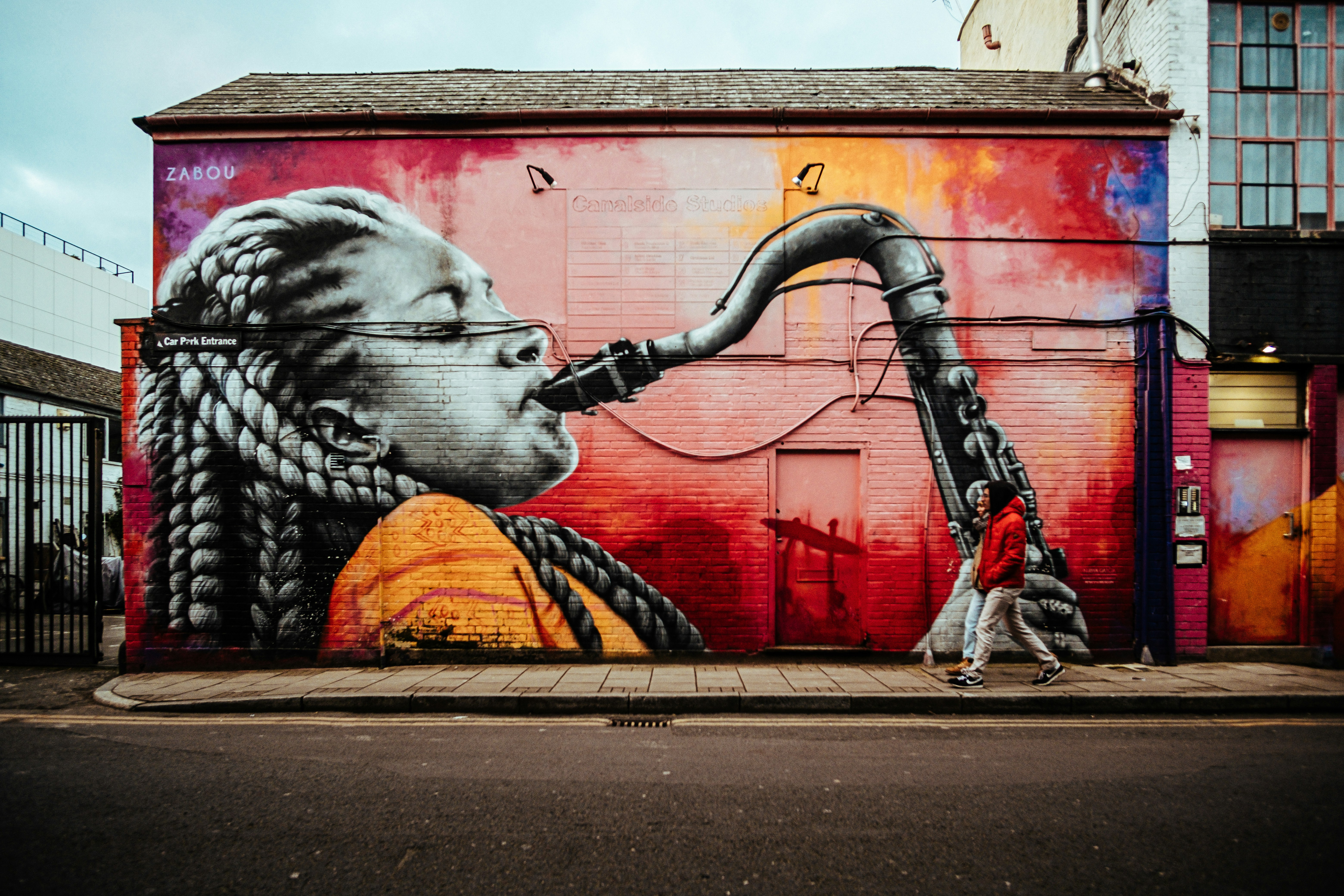 man in black and white tiger costume holding black and yellow hose, 