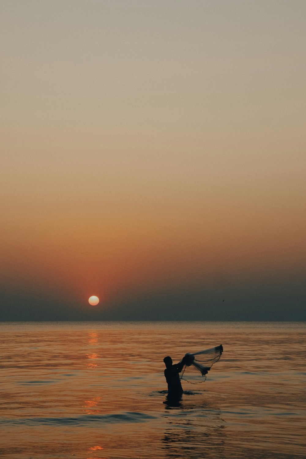 silhouette of man riding on boat during sunset