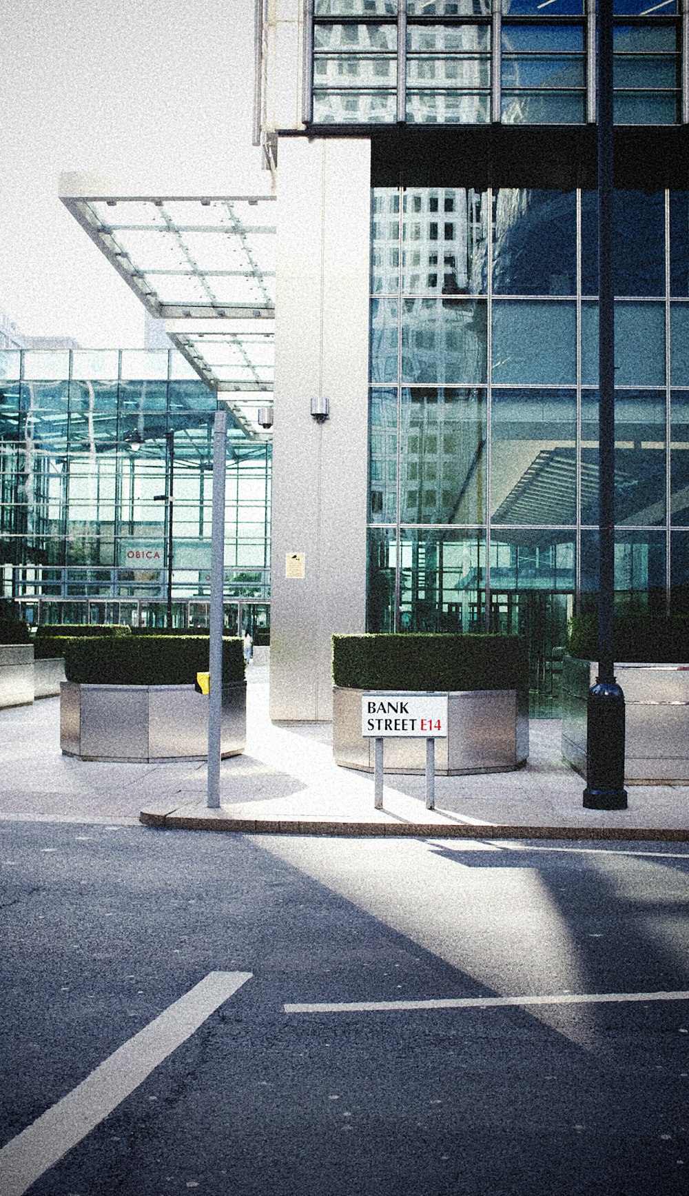 black trash bin near glass building