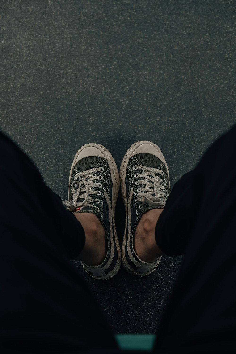 person wearing black pants and gray and white sneakers