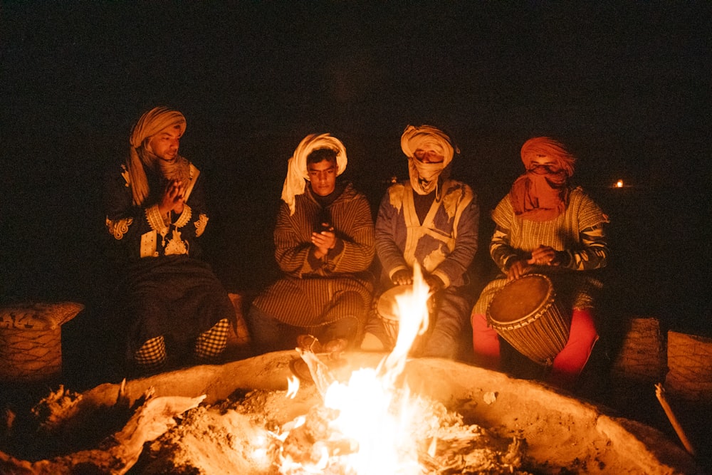 Gruppe von Menschen sitzt auf dem Stuhl vor dem Lagerfeuer