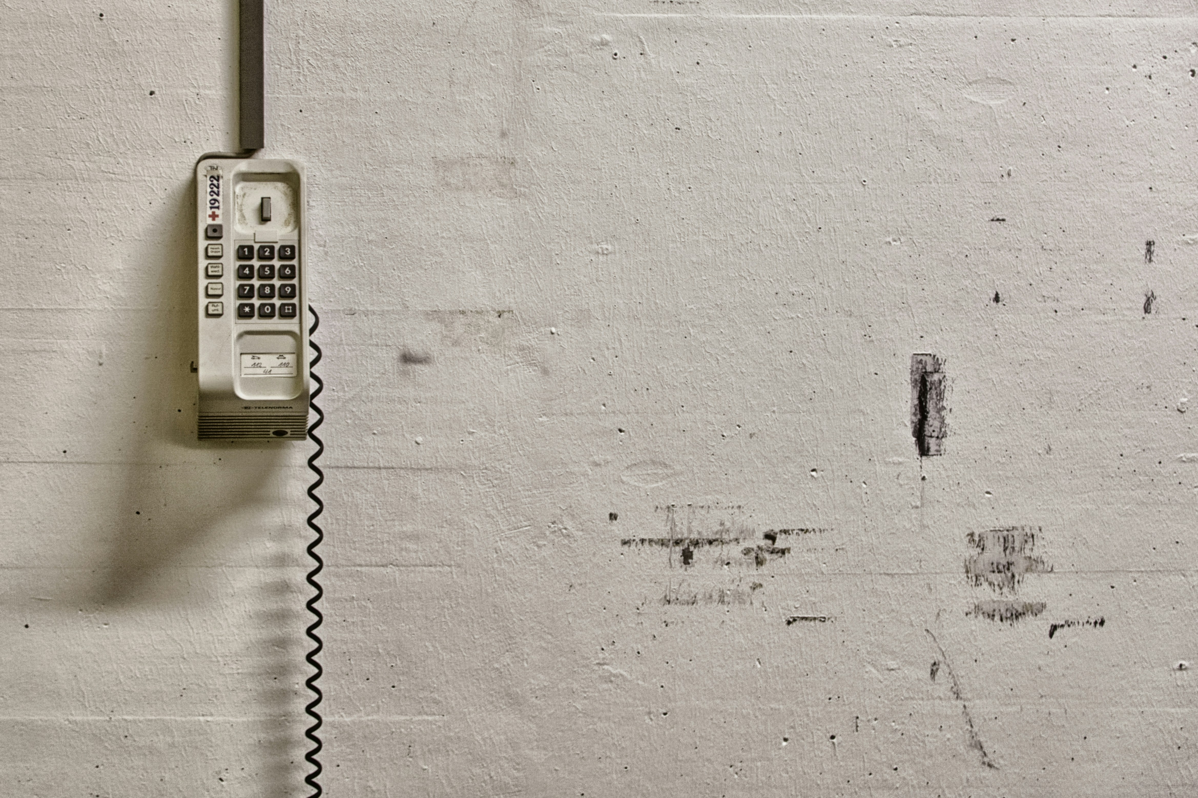 white wall mounted phone on white wall