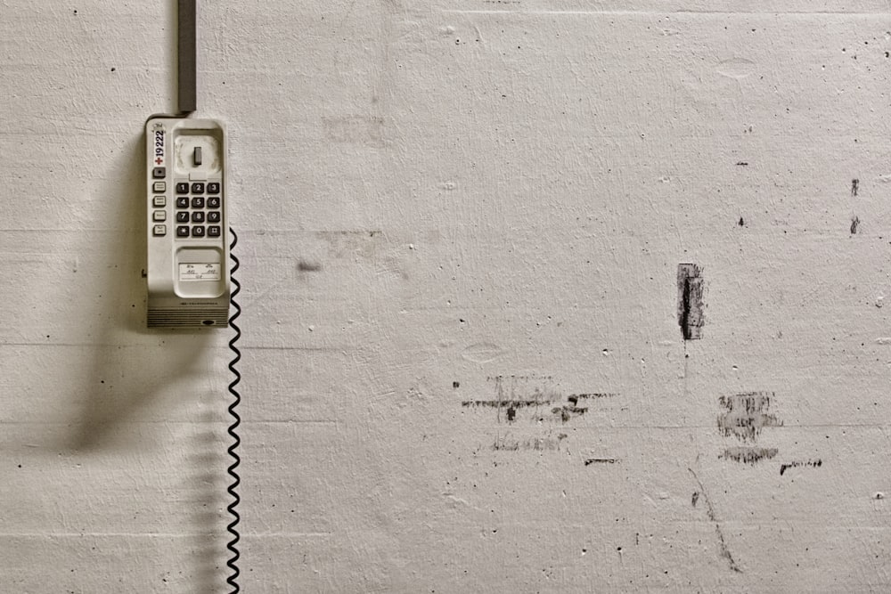 Teléfono montado en la pared blanca en la pared blanca