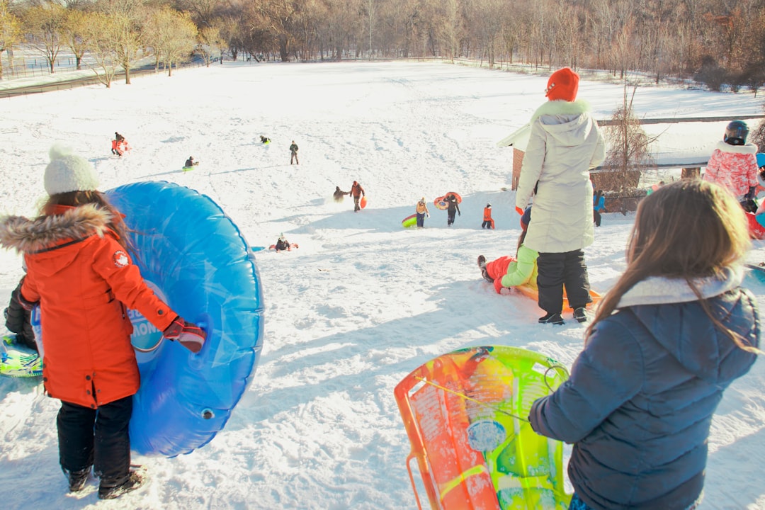 people playing on snow covered field during daytime