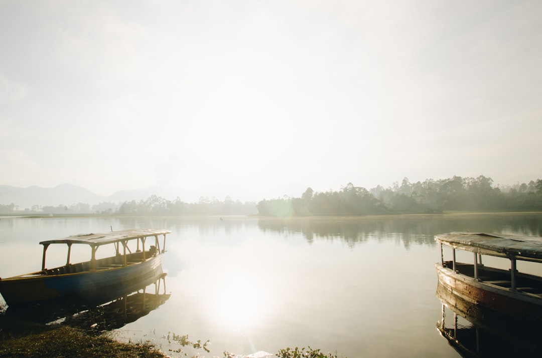 brown boat on calm water during foggy weather