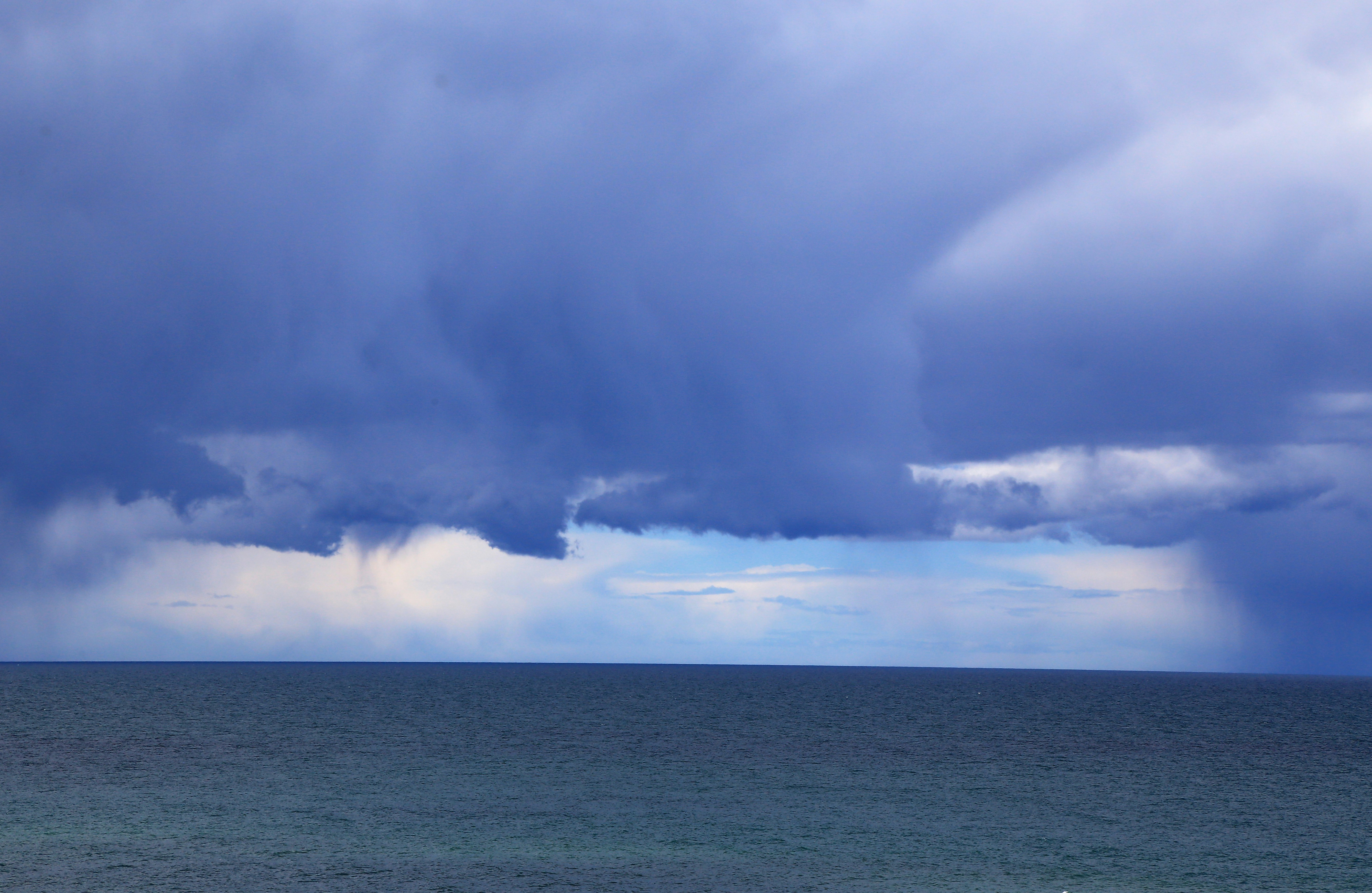 Dramatic sky with a heavy cloud curtain hovering over the ocean