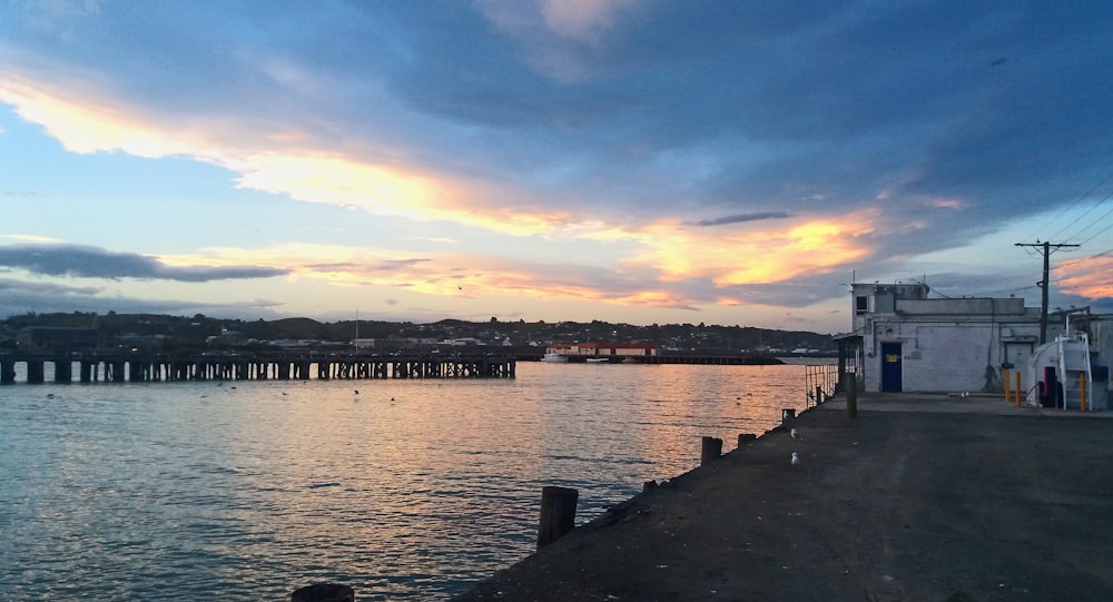 body of water under cloudy sky during sunset