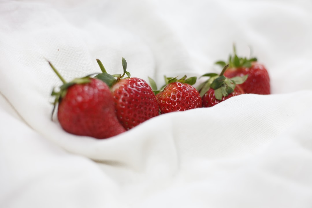 red strawberries on white textile