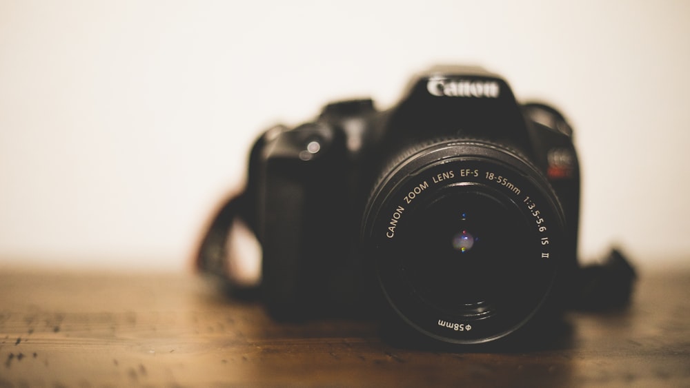 black nikon dslr camera on brown wooden table